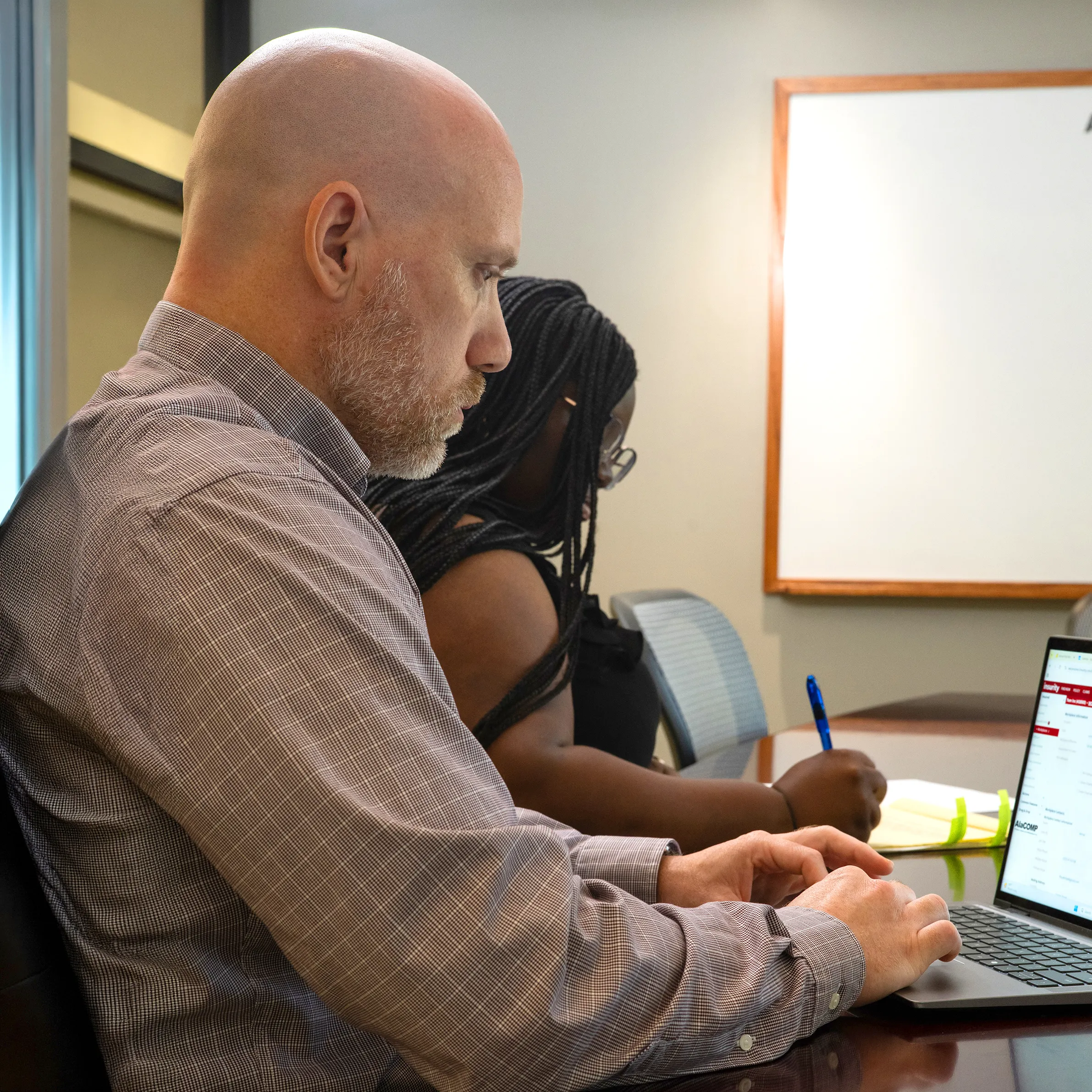 AlaCOMP team members reviewing workers’ compensation information during a meeting.