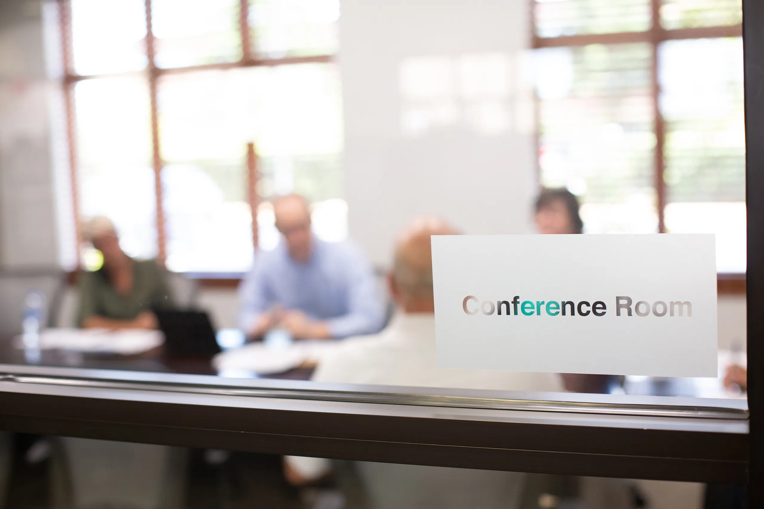 AlaCOMP team members meeting in a glass-walled conference room.